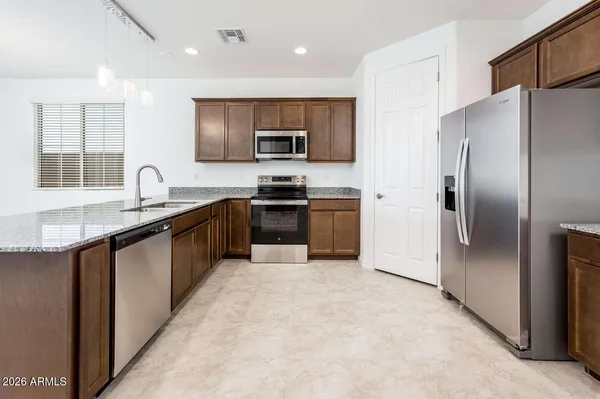 a kitchen with granite countertop a sink and stainless steel appliances