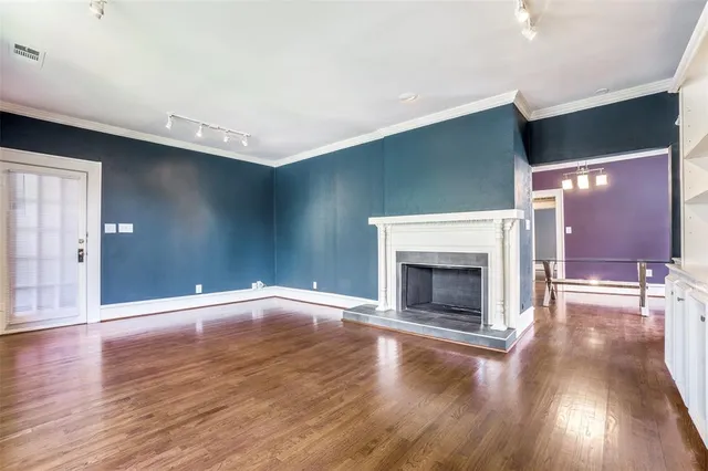 a view of empty room with wooden floor and fireplace