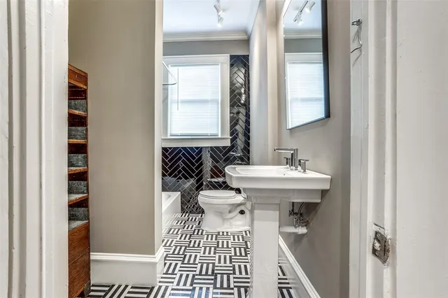 a bathroom with a sink a toilet and a window