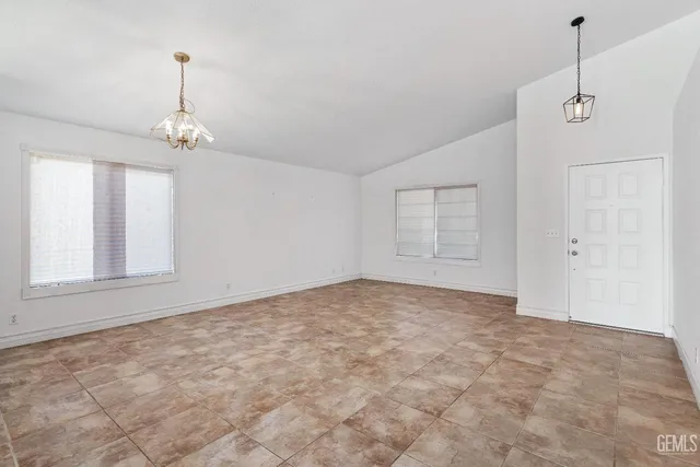 an empty room with windows and ceiling fan
