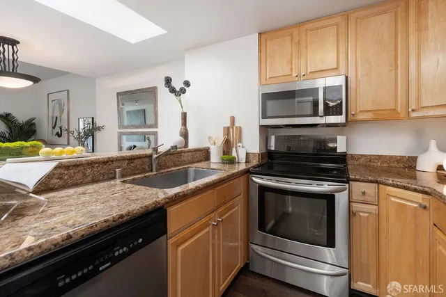 a kitchen with granite countertop stainless steel appliances a stove sink and microwave