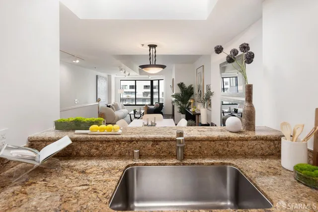 a kitchen with granite countertop a stove a sink and a dining table