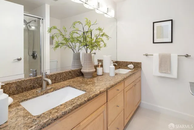 a bathroom with a granite countertop sink and a mirror