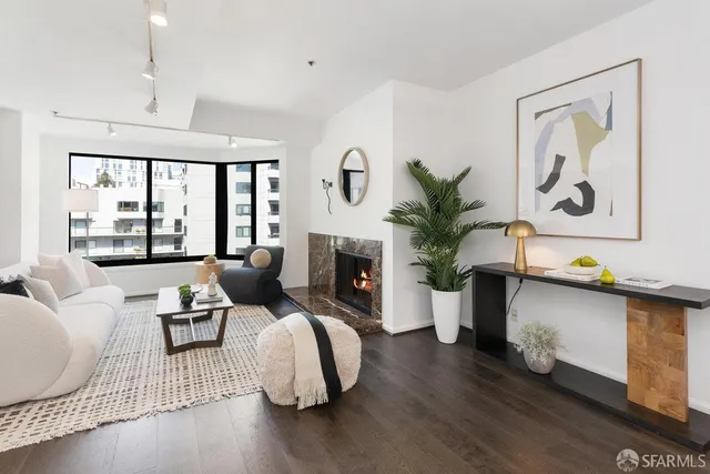 a living room with furniture large window and wooden floor