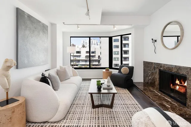 a living room with furniture a rug a fireplace and a large window