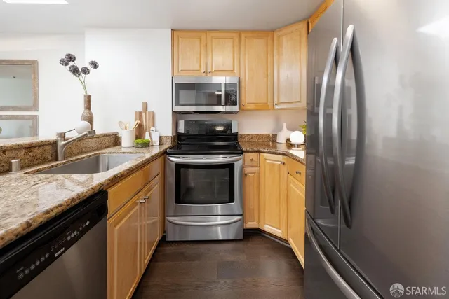 a kitchen with stainless steel appliances granite countertop a sink stove and refrigerator