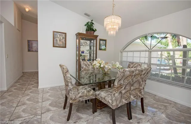 a view of a dining room with furniture a chandelier and wooden floor