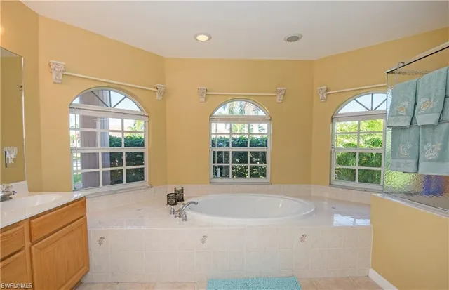 a bathroom with a tub sink and mirror