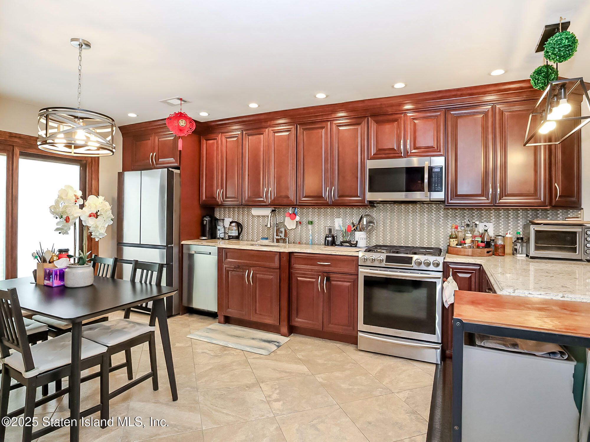 31 Pierpont Place Staten Island, NY 10314 - Photo 8 of 23 a kitchen with stainless steel appliances granite countertop a stove top oven a sink dishwasher a dining table and chairs with wooden floor