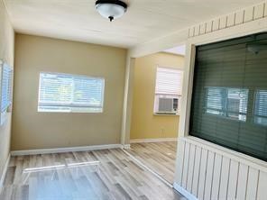1220 Winnie Rear Street Galveston, TX 77550 - Photo 2 of 10 a view of an empty room with wooden floor and a window