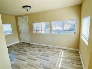 1220 Winnie Rear Street Galveston, TX 77550 - Photo 3 of 10 a view of an empty room with wooden floor and a window