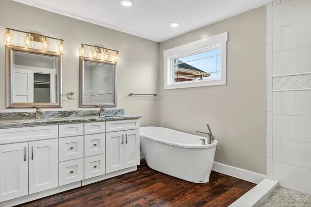 a bathroom with a granite countertop sink and a mirror