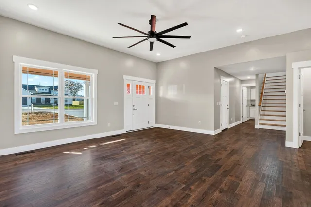 a view of a livingroom with a ceiling fan and wooden floor