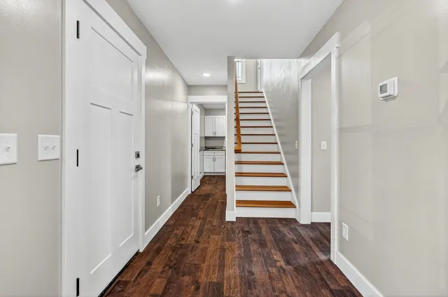 a view of a hallway with wooden floor and entryway