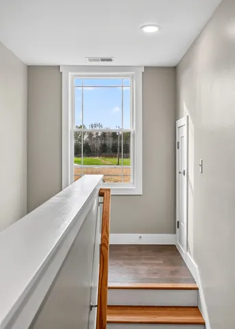a view of a bedroom with wooden floor and a window