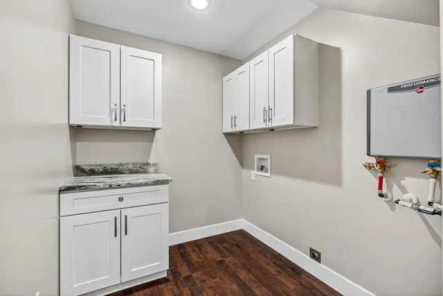 a kitchen with granite countertop white cabinets and white appliances