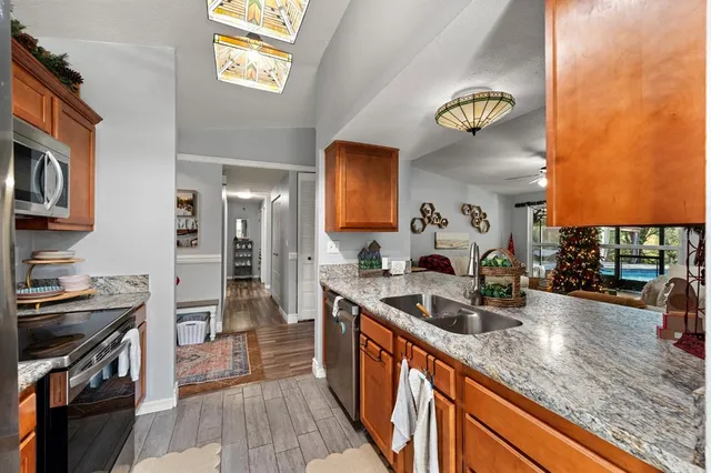 a kitchen with stainless steel appliances granite countertop a sink stove and refrigerator