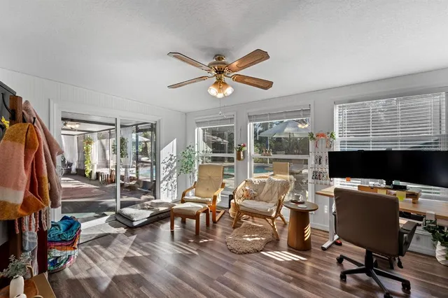 a living room with furniture a flat screen tv and a floor to ceiling window