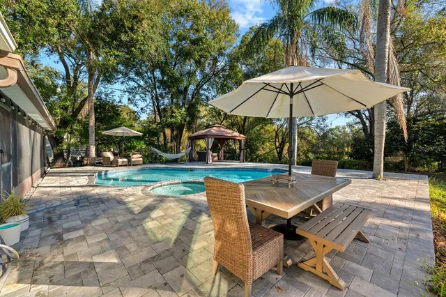 a view of a swimming pool with sitting area and furniture