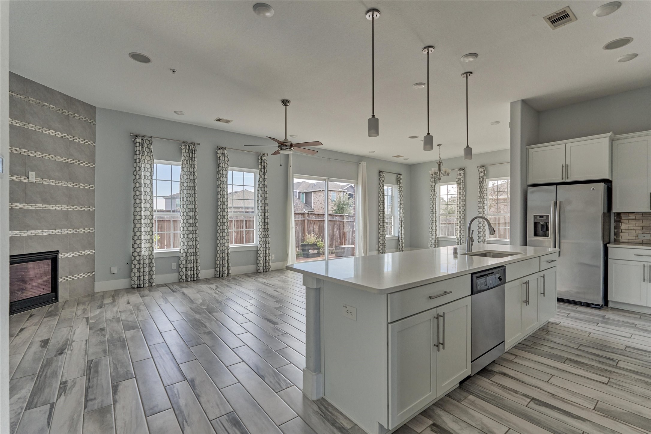 2113 Solstice Boulevard Spring, TX 77386 - Photo 14 of 50 a large kitchen with kitchen island a large island wooden floor stainless steel appliances and windows