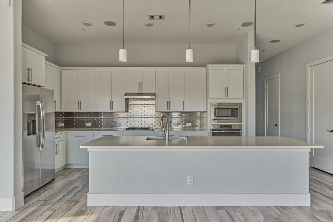 2113 Solstice Boulevard Spring, TX 77386 - Photo 2 of 50 a large kitchen with stainless steel appliances kitchen island a large counter top and white cabinets