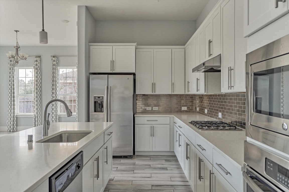 2113 Solstice Boulevard Spring, TX 77386 - Photo 25 of 50 a kitchen with stainless steel appliances granite countertop a sink stove and refrigerator
