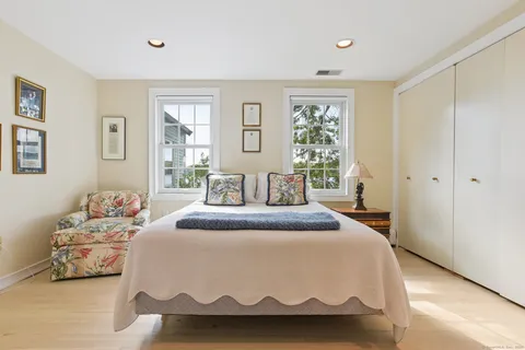 a spacious bedroom with a bed and wooden floor