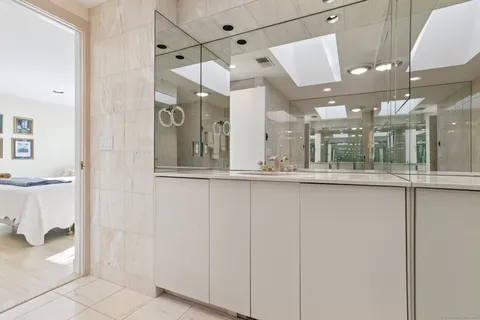 a view of a hallway with a glass door shower and furniture
