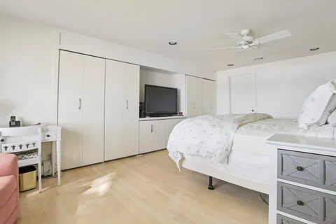 a spacious bedroom with a bed and a flat screen tv