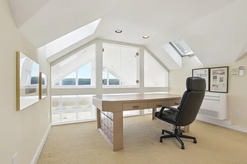 a view of a workspace with furniture and a window