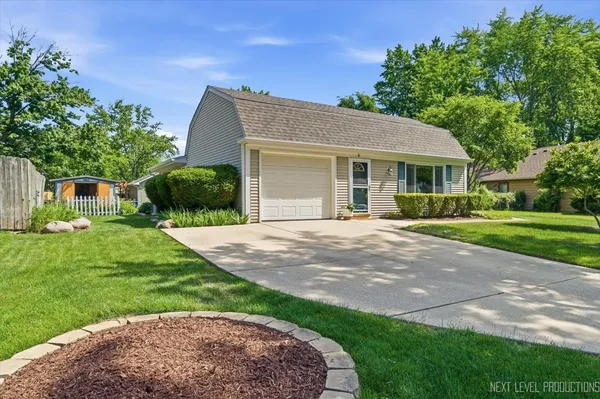 a front view of a house with a yard and potted plants