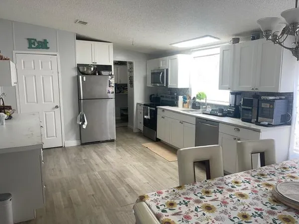 a kitchen with stainless steel appliances granite countertop a refrigerator a stove a sink dishwasher a microwave oven with cabinets and wooden floor