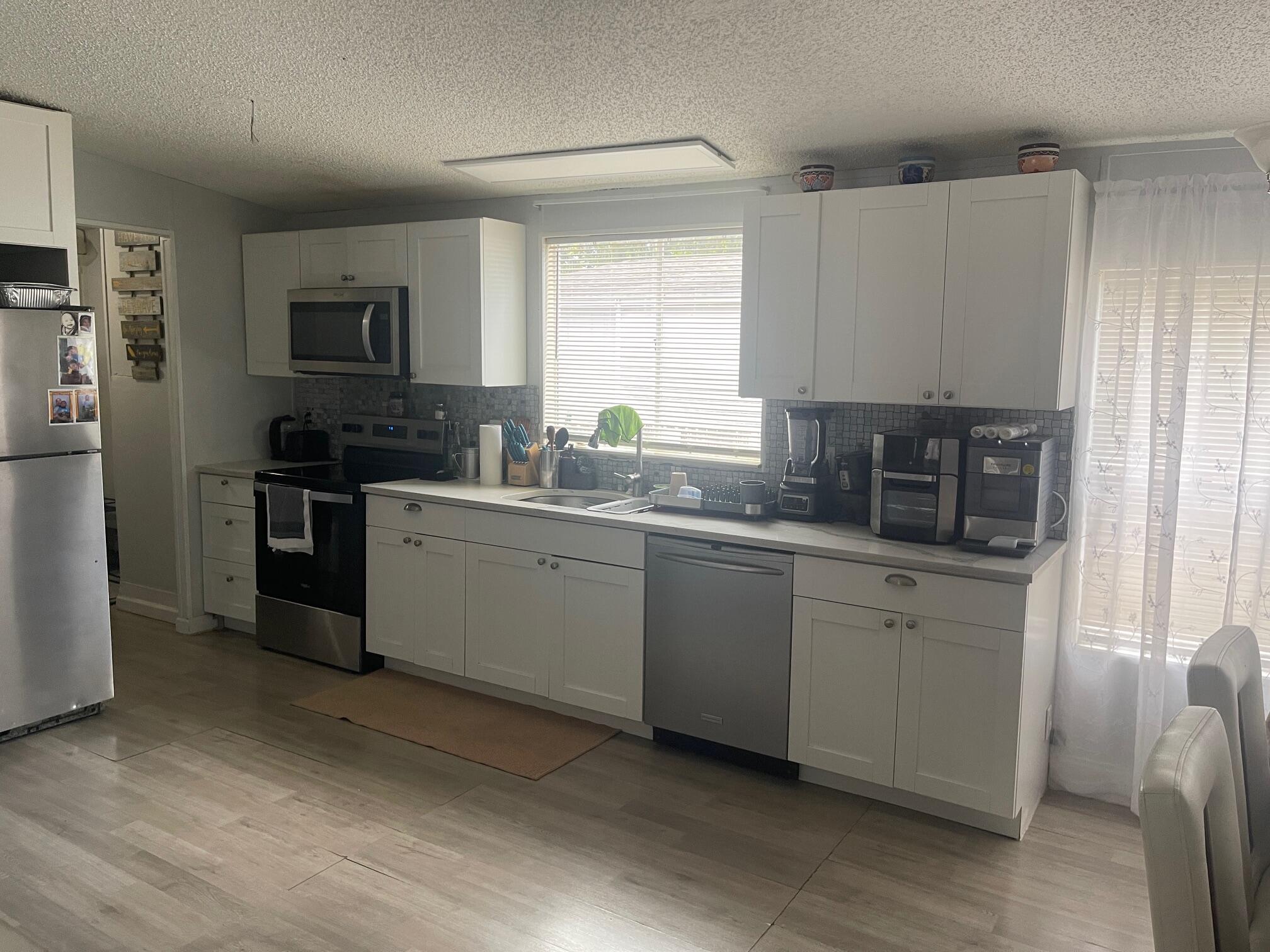 10552 Marina Way Boca Raton, FL 33428 - Photo 4 of 22 a kitchen with stainless steel appliances granite countertop a sink stove and refrigerator