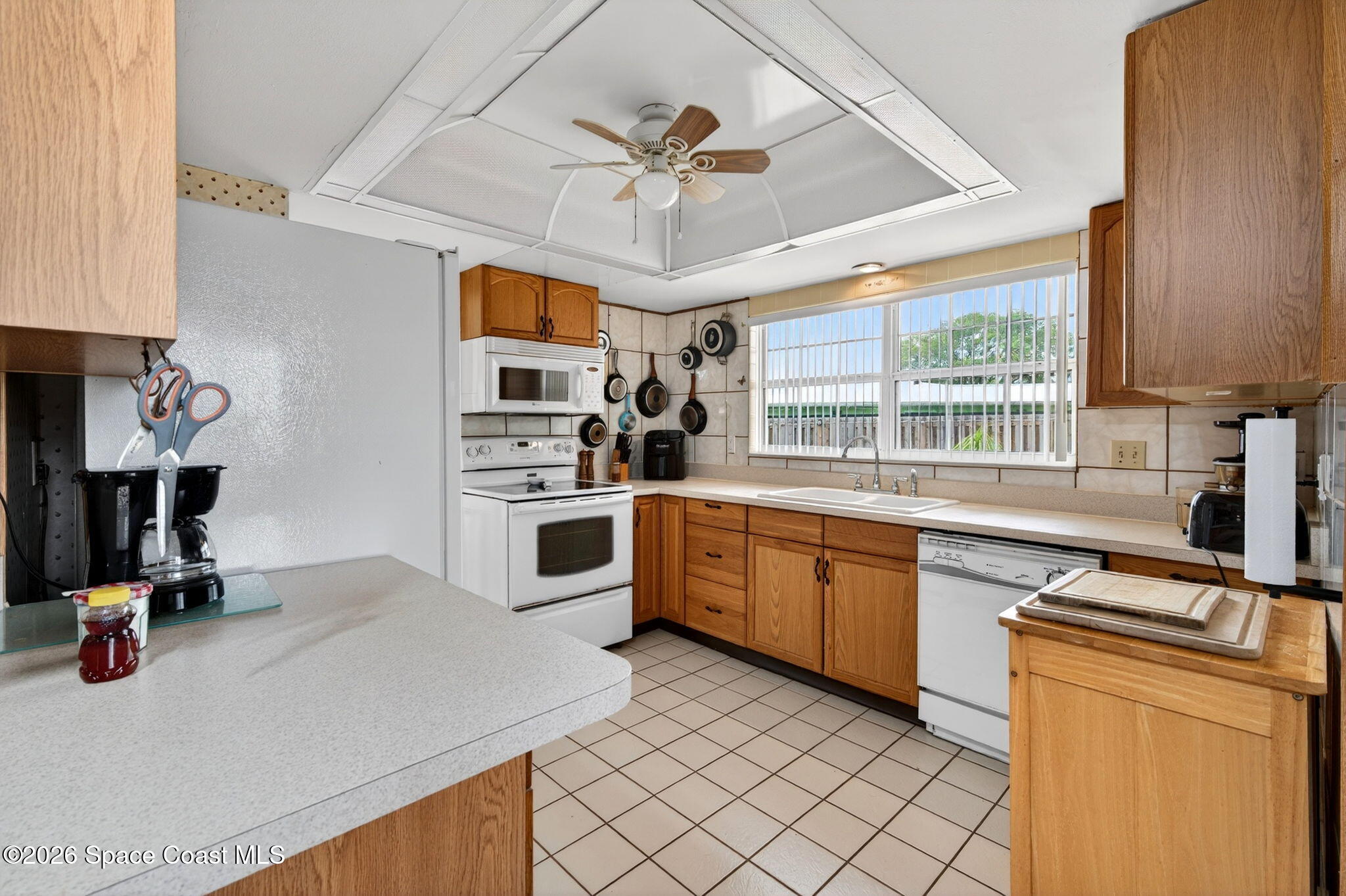 956 Waialae Circle Northeast Palm Bay, FL 32905 - Photo 23 of 45 a kitchen with stainless steel appliances granite countertop a sink dishwasher stove and white cabinets with wooden floor
