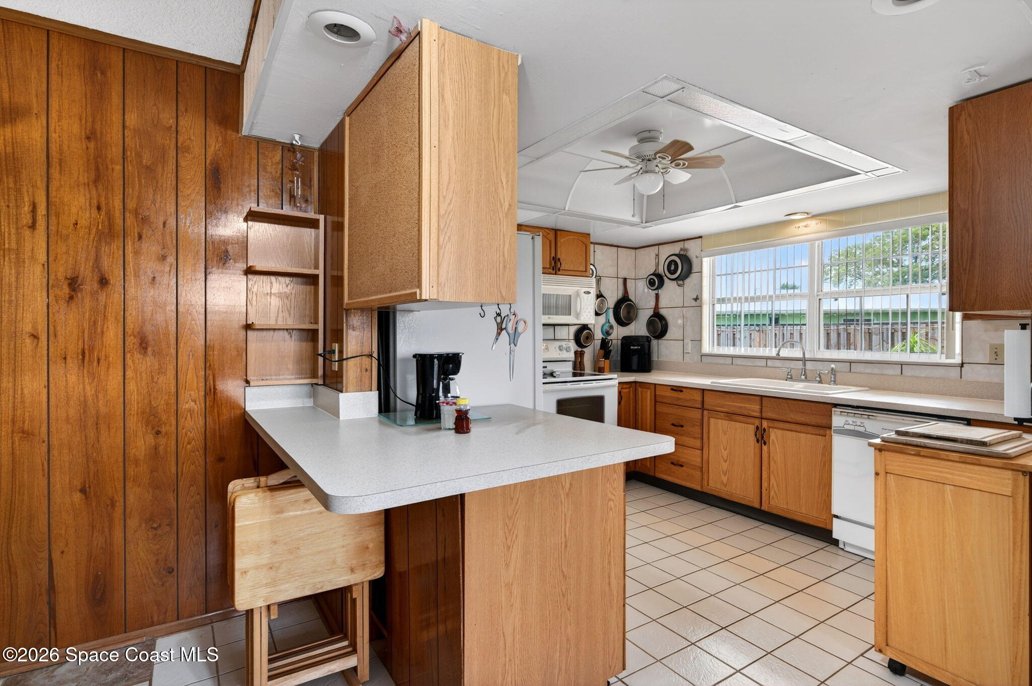 956 Waialae Circle Northeast Palm Bay, FL 32905 - Photo 24 of 45 a kitchen with stainless steel appliances granite countertop a sink dishwasher and a refrigerator with wooden floor
