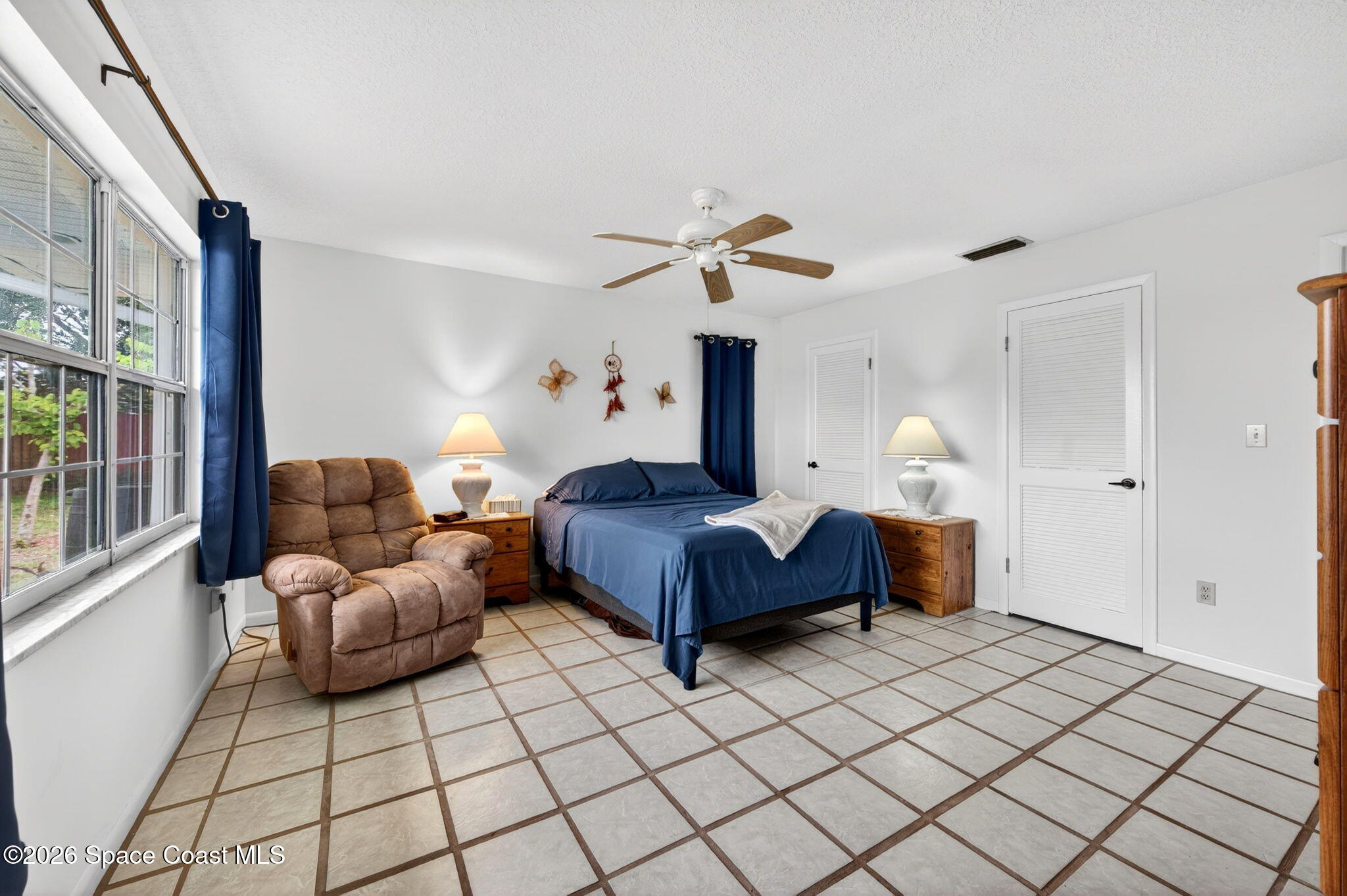 956 Waialae Circle Northeast Palm Bay, FL 32905 - Photo 29 of 45 a spacious bedroom with a bed and window