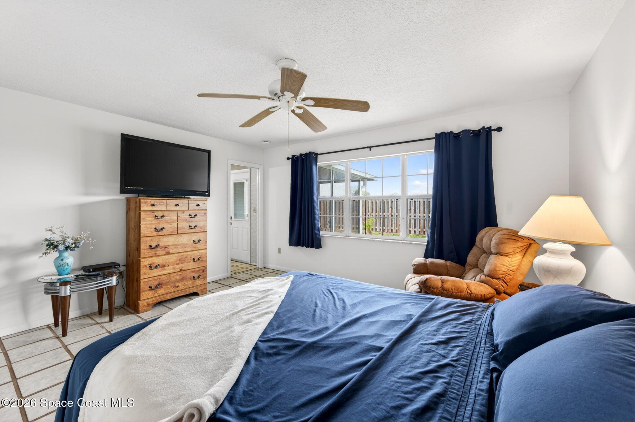 956 Waialae Circle Northeast Palm Bay, FL 32905 - Photo 30 of 45 a bedroom with a bed and furniture with a flat tv screen