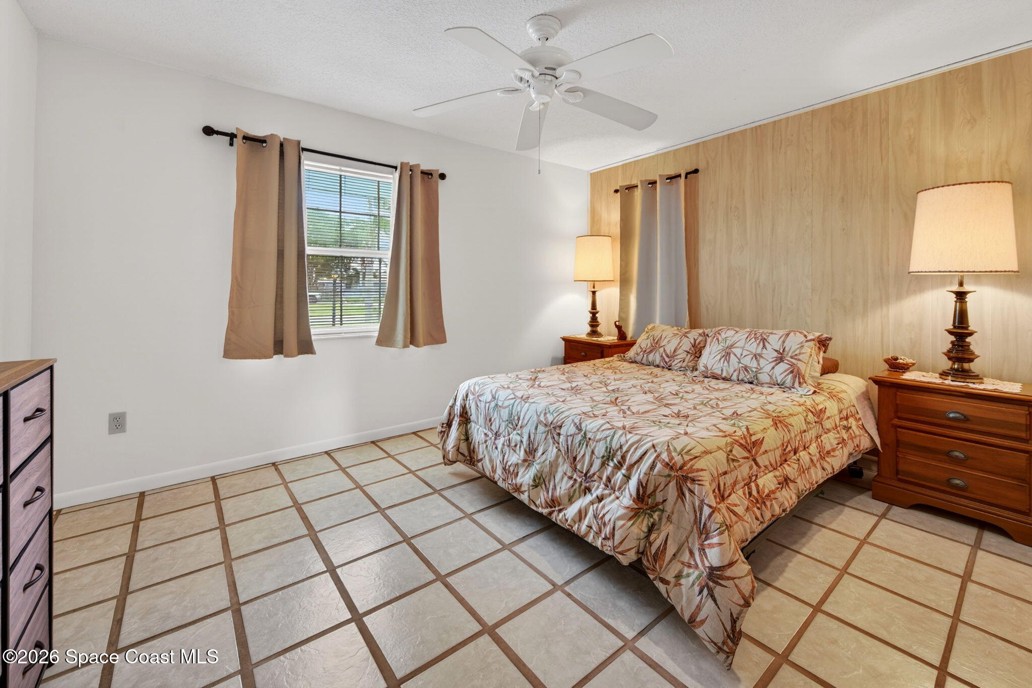 956 Waialae Circle Northeast Palm Bay, FL 32905 - Photo 33 of 45 a bedroom with a bed and a lamp on dresser