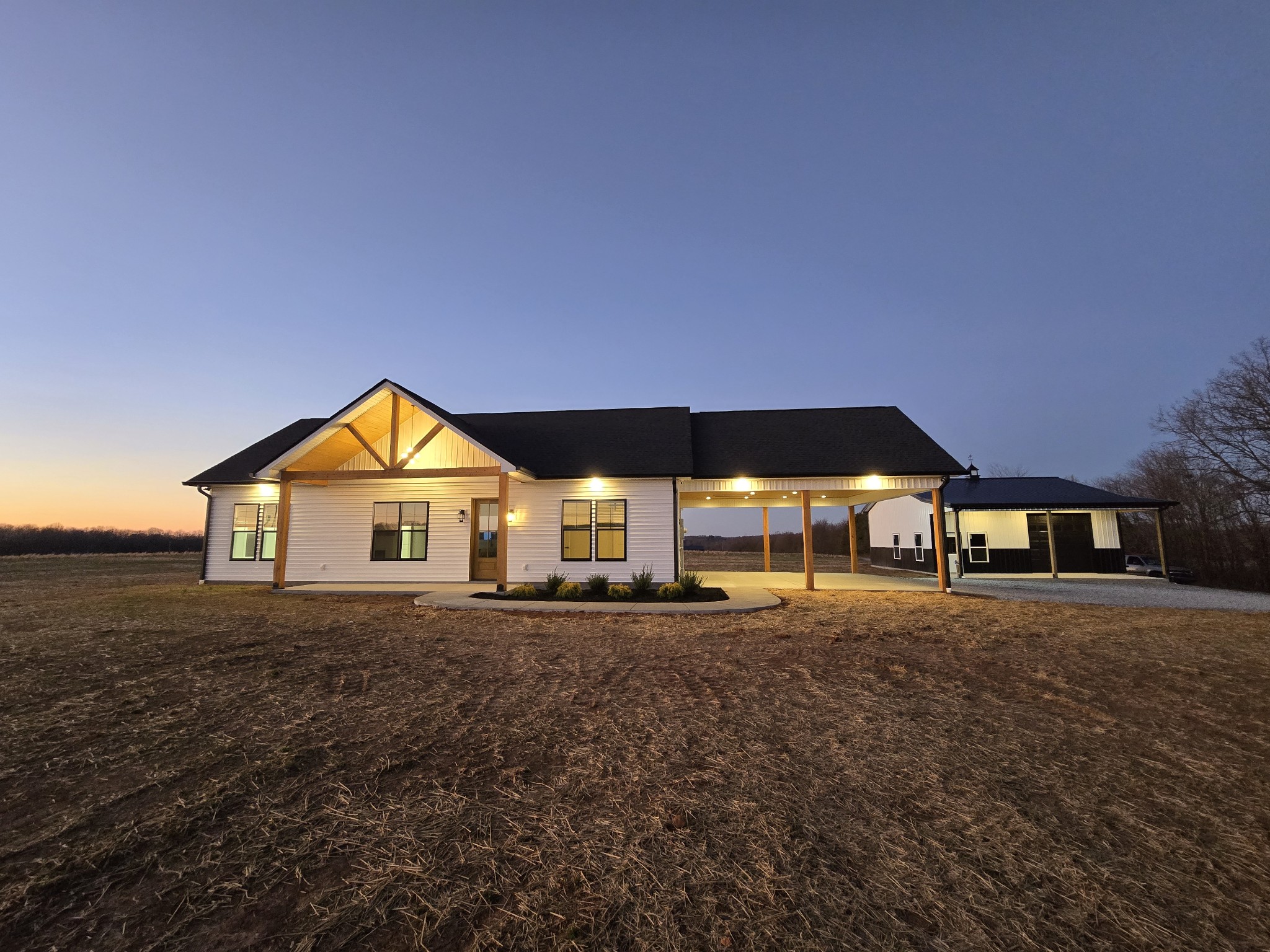 a view of a large house with a big yard and large trees