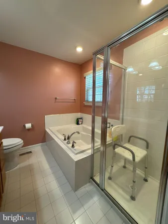 a bathroom with a tub a toilet and a shower