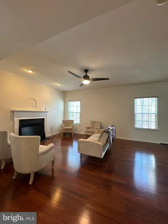 a living room with fireplace furniture and a wooden floor