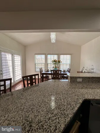 a large kitchen with kitchen island granite countertop a sink and cabinets