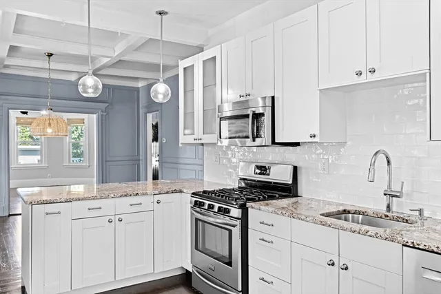 a kitchen with stainless steel appliances granite countertop a sink a stove and cabinets