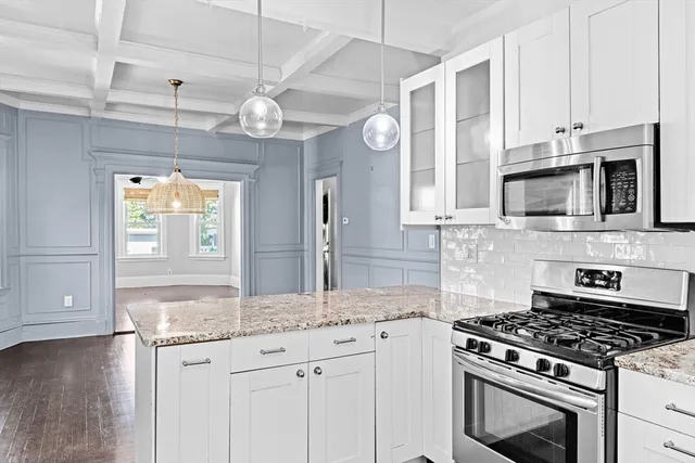 a kitchen with stainless steel appliances granite countertop a stove and a microwave