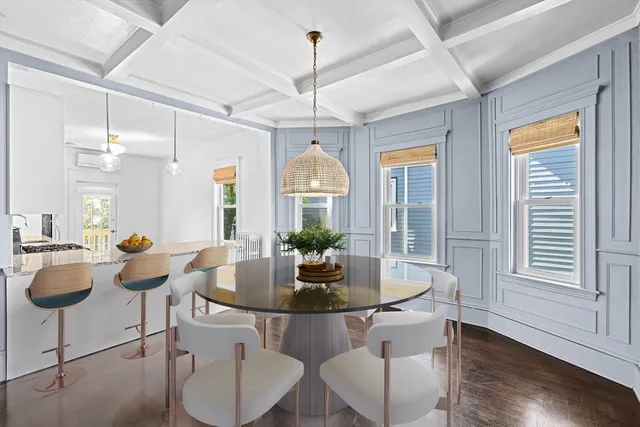 a dining room with furniture a chandelier and wooden floor
