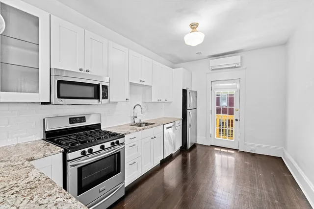 a kitchen with stainless steel appliances a stove cabinets and wooden floor
