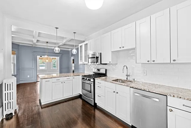 a kitchen with granite countertop white cabinets and white appliances