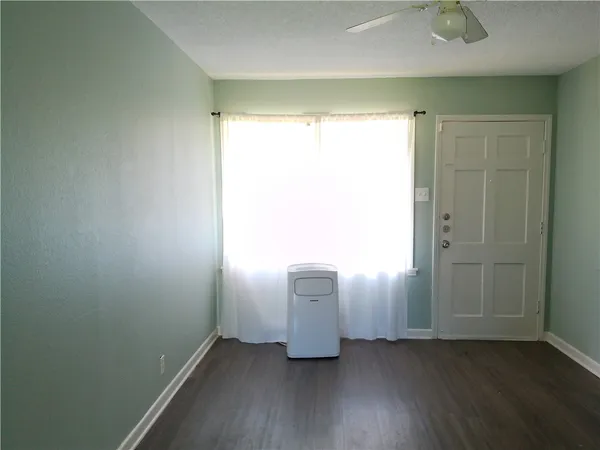 a view of a room with wooden floor and a bathroom