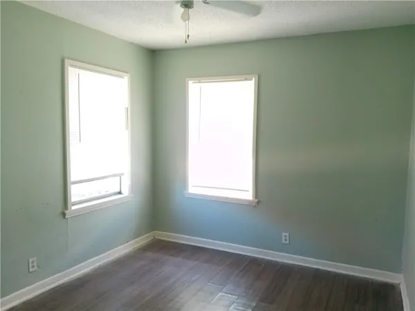 an empty room with wooden floor and a window