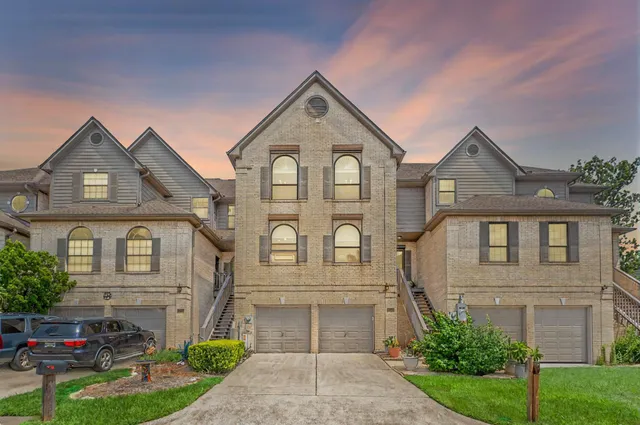 a front view of a house with a garden and trees